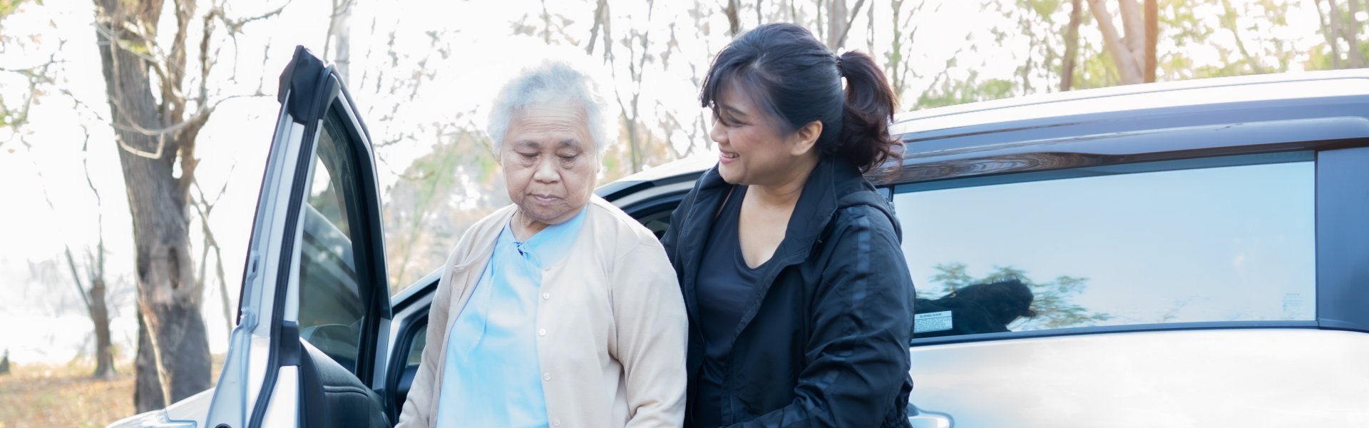 a woman assisting elderly out of the car